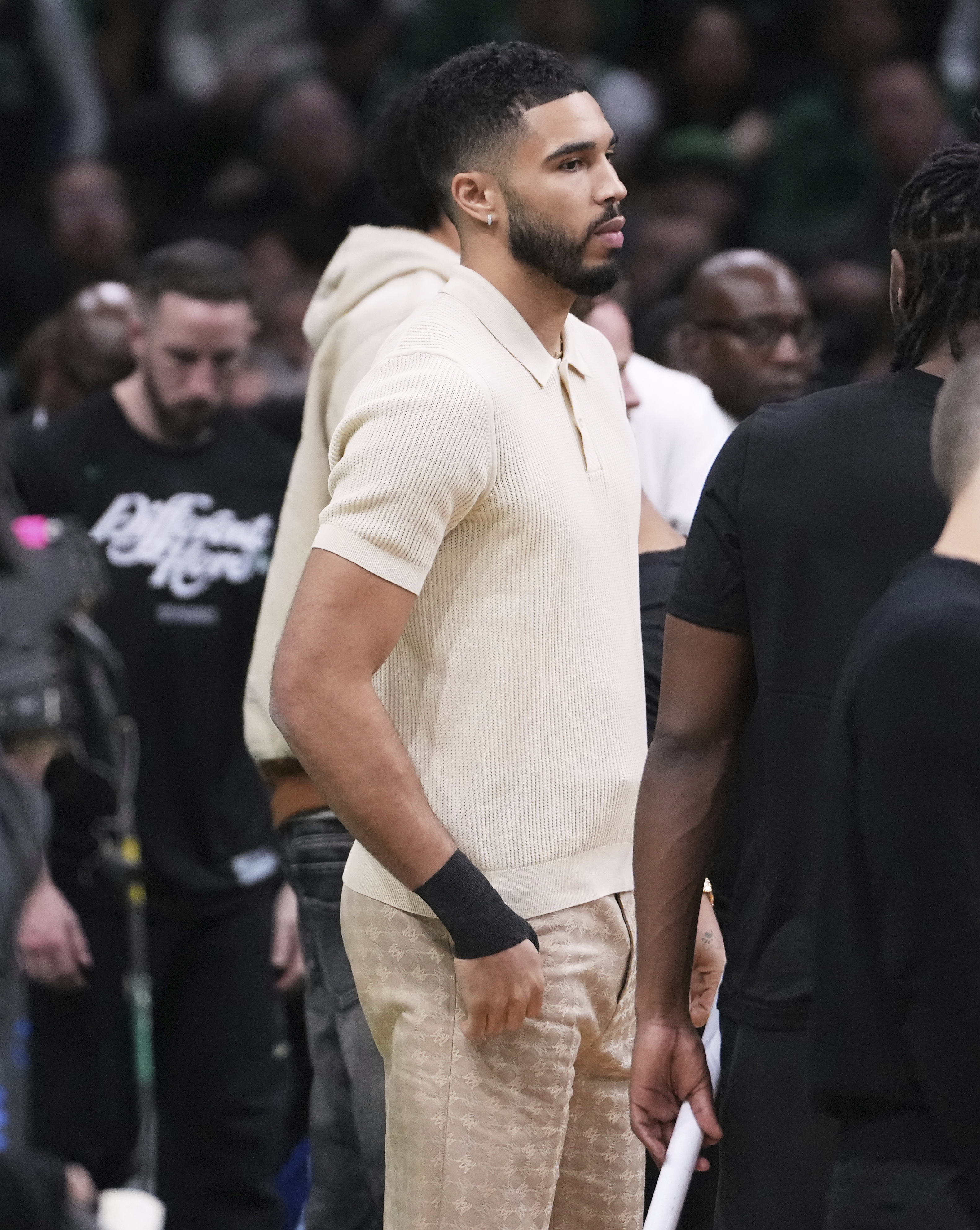 Boston Celtics forward Jayson Tatum, who is sidelined with an injury, stands near the bench with his wrist wrapped during the first half in game 2 of a first-round NBA playoff basketball series against the Orlando Magic, Wednesday, April 23, 2025, in Boston. (AP Photo/Charles Krupa)