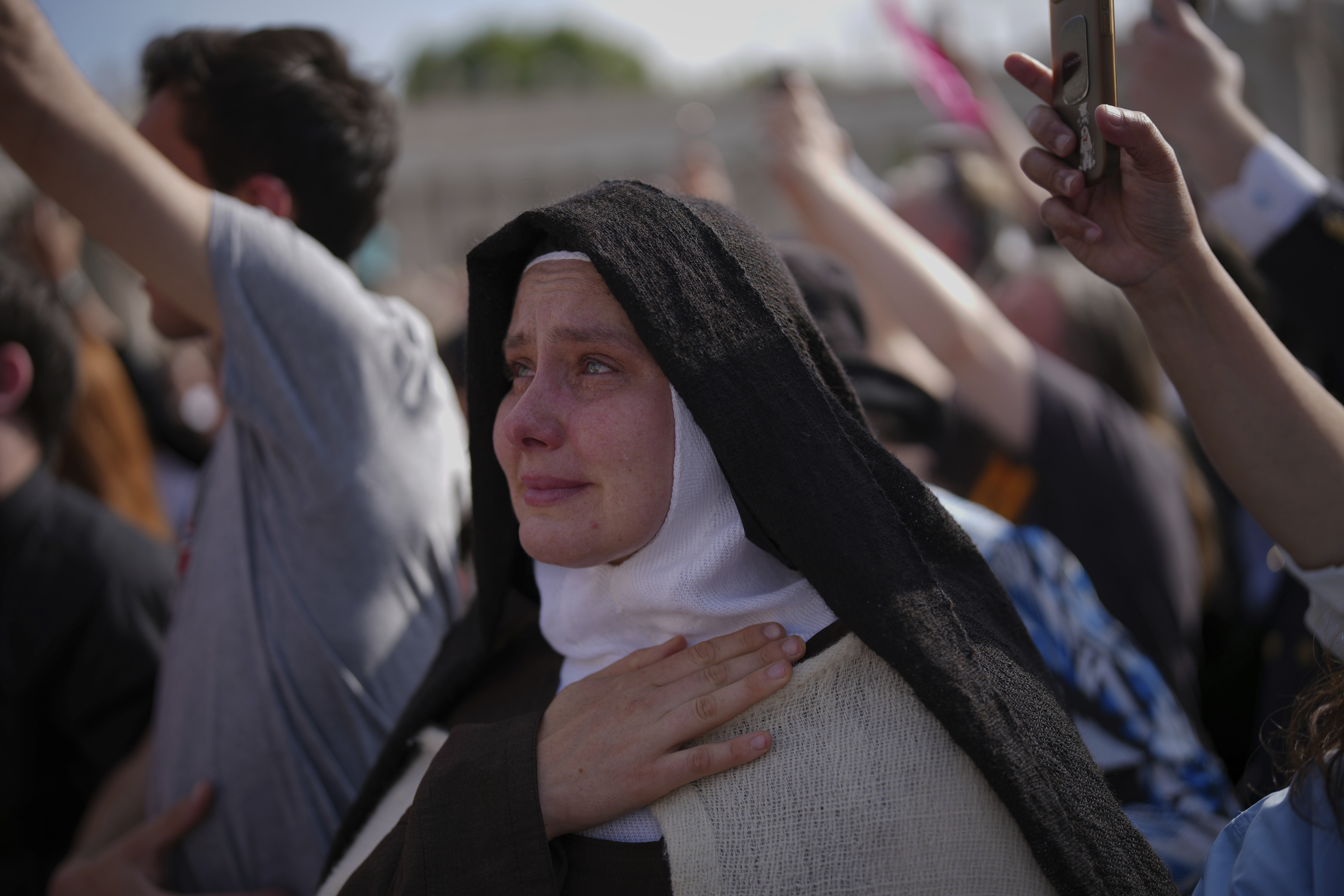 A nun cries as the body of Pope Francis is carried into St. Peter's Basilica at the Vatican, Wednesday, April 23, 2025, where he will lie in state for three days. (AP Photo/Emilio Morenatti)