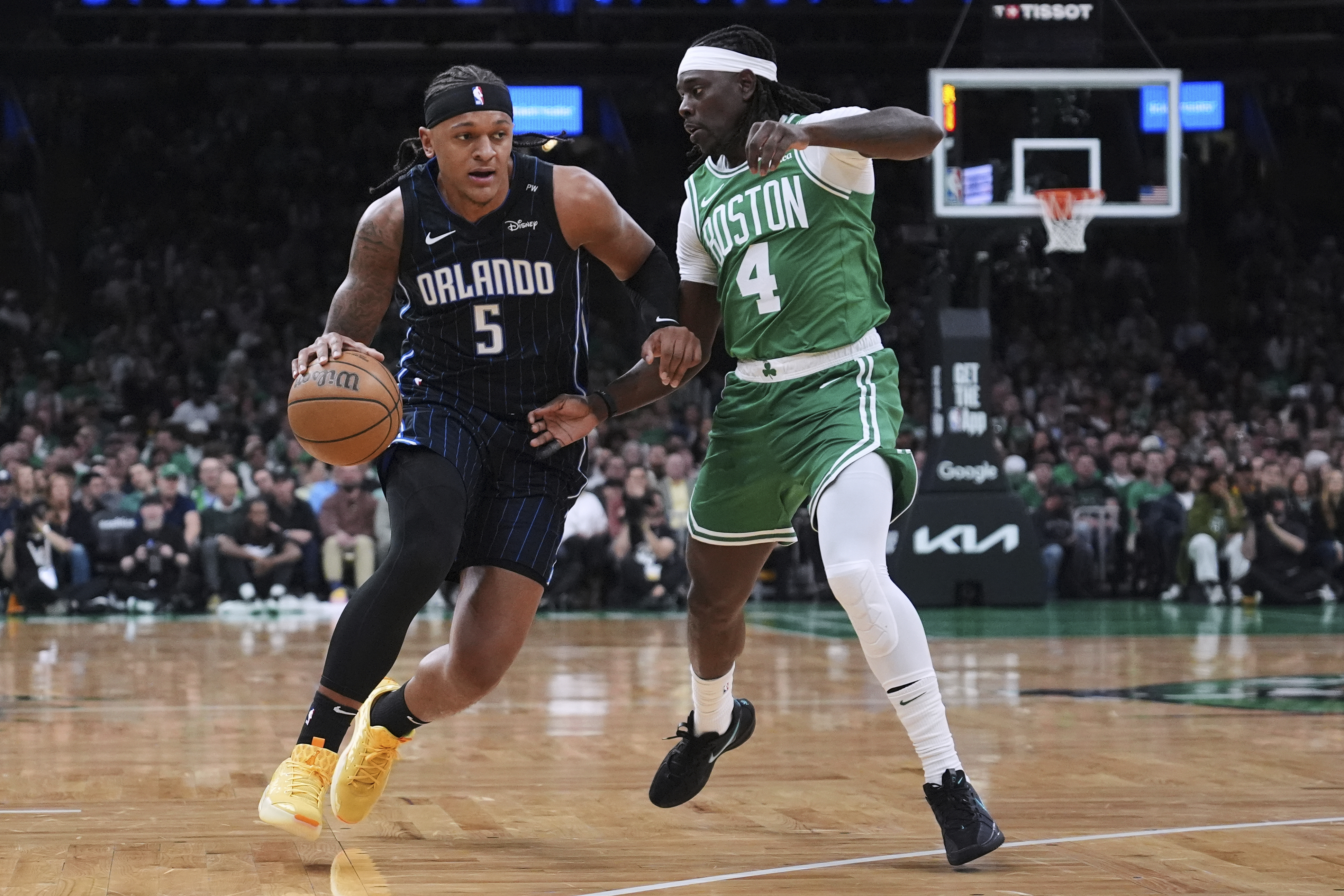 Orlando Magic forward Paolo Banchero (5) drives to the basket against Boston Celtics guard Jrue Holiday (4) during the first half in game 2 of a first-round NBA playoff basketball series, Wednesday, April 23, 2025, in Boston. (AP Photo/Charles Krupa)