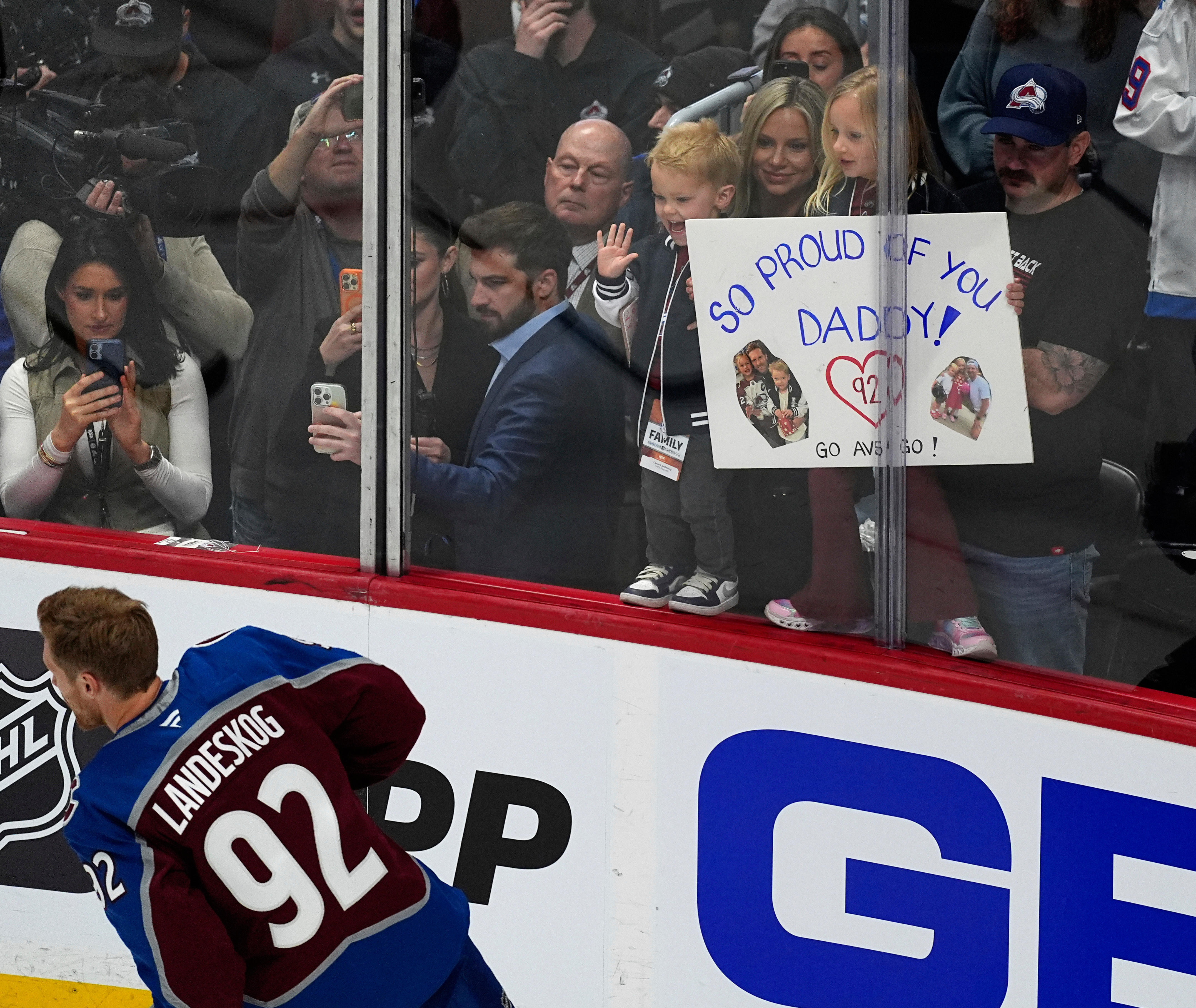Family members hold up a placard in support of Colorado Avalanche left wing Gabriel Landeskog as he warms up before the first period of Game 3 of an NHL first-round hockey playoff series against the Dallas Stars Wednesday, April 23, 2025, in Denver. (AP Photo/David Zalubowski)