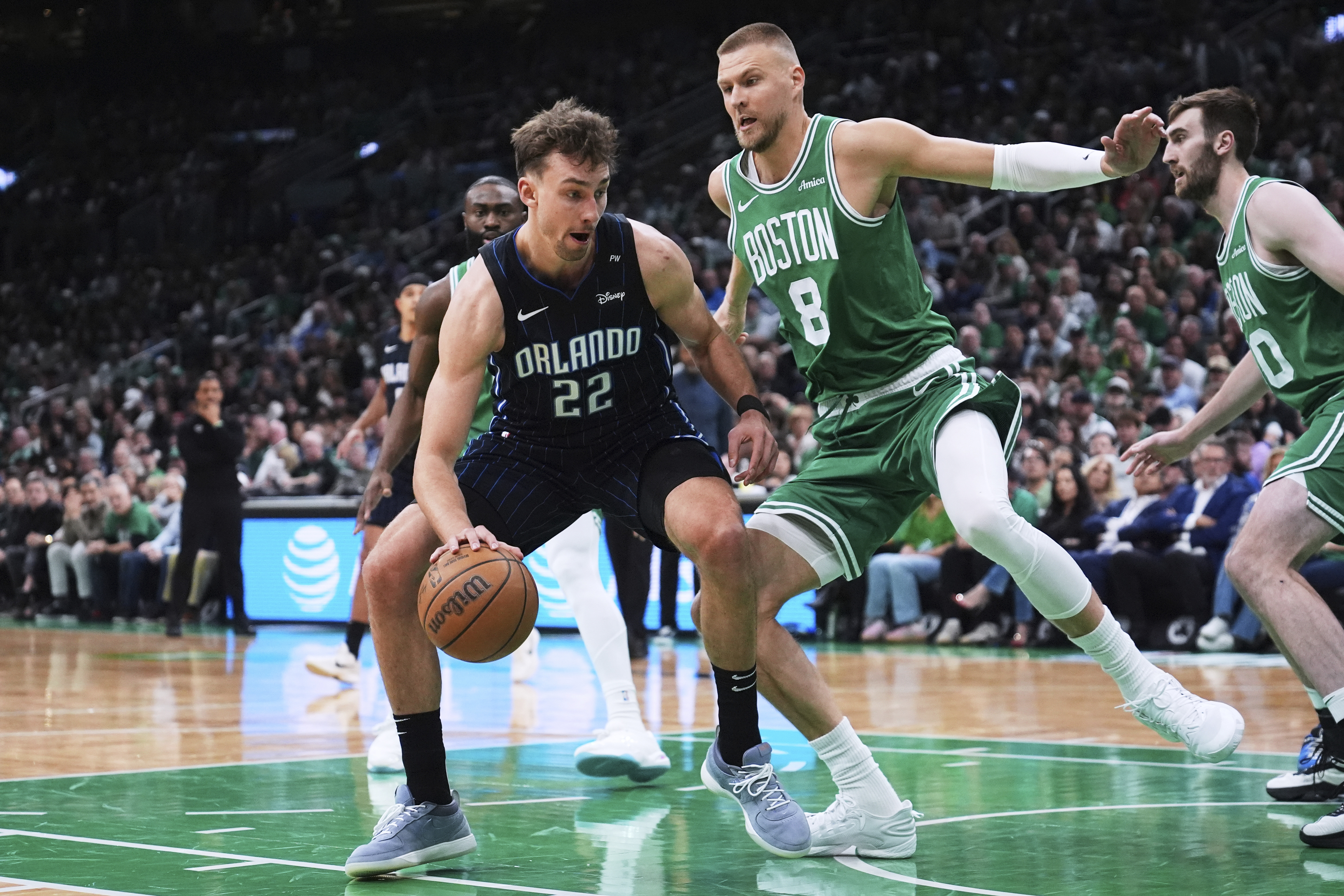 Orlando Magic forward Franz Wagner (22) drives to the basket against Boston Celtics center Kristaps Porzingis (8) during the first half in game 2 of a first-round NBA playoff basketball series, Wednesday, April 23, 2025, in Boston. (AP Photo/Charles Krupa)
