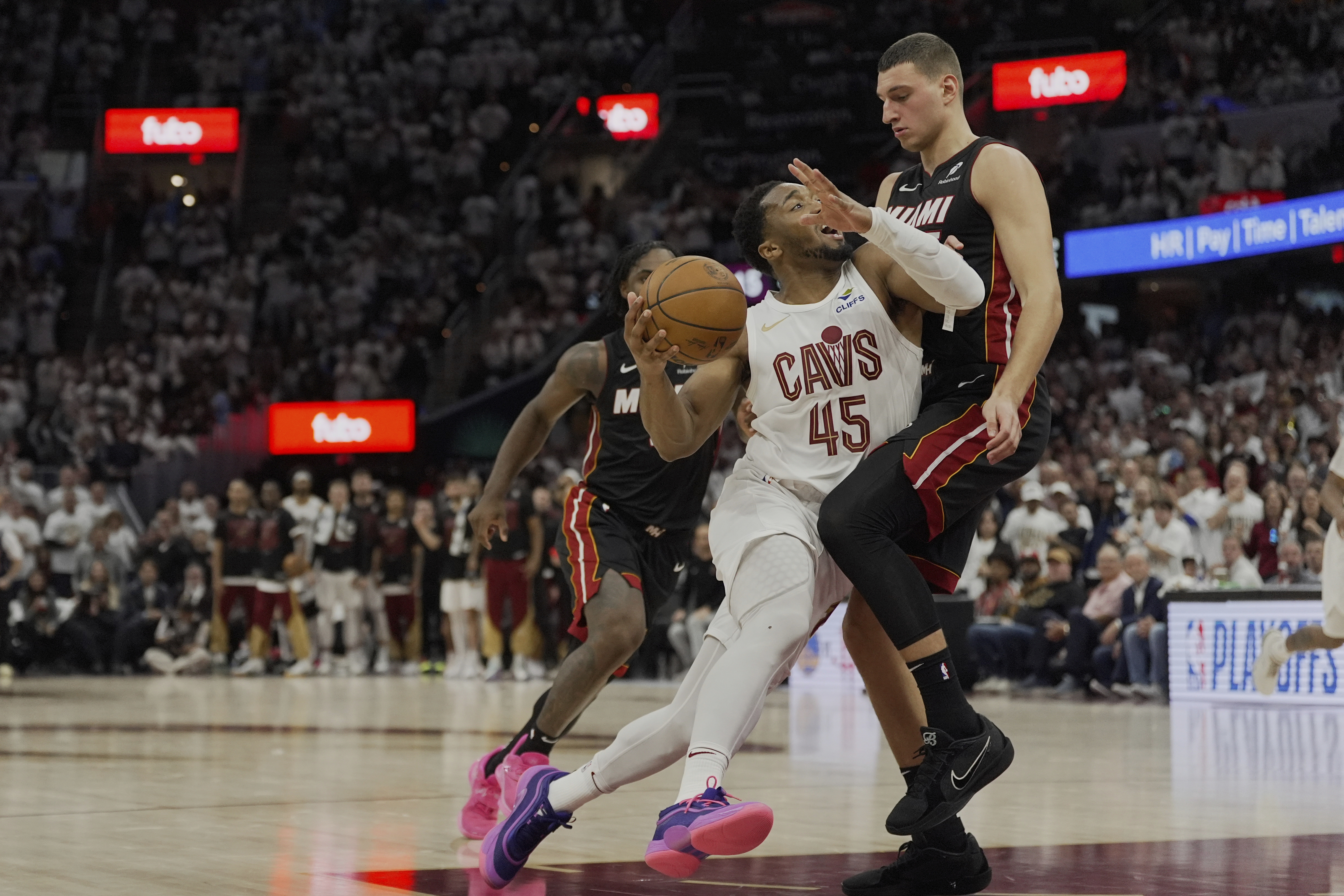 Cleveland Cavaliers guard Donovan Mitchell (45) drives against Miami Heat forward Nikola Jovic, right, in the second half in Game 2 of an NBA first-round playoff series, Wednesday, April 23, 2025, in Cleveland. (AP Photo/Sue Ogrocki)
